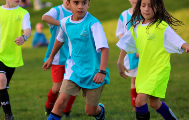 A child kicks a soccer ball during a soccer game.